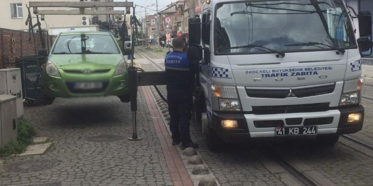 Tramvay yoluna park edilen araçlar çekiliyor