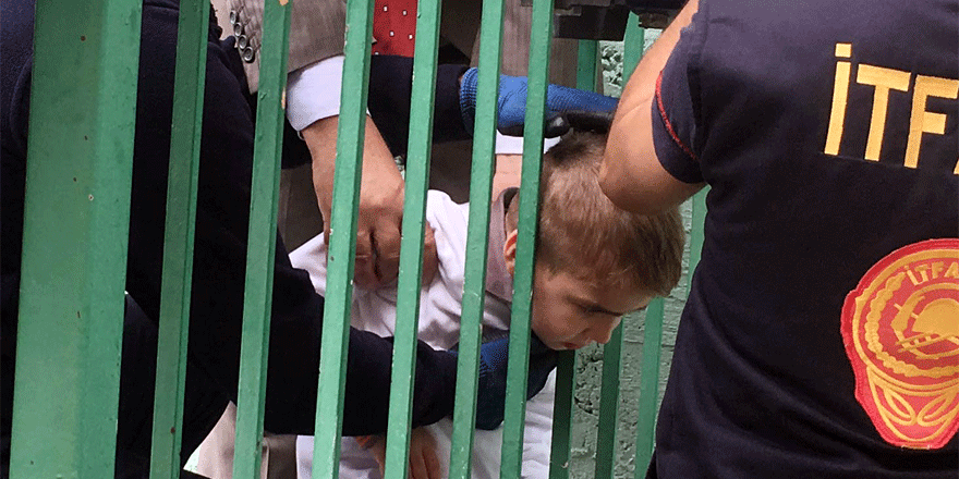 Başını korkuluklara sıkıştırdı